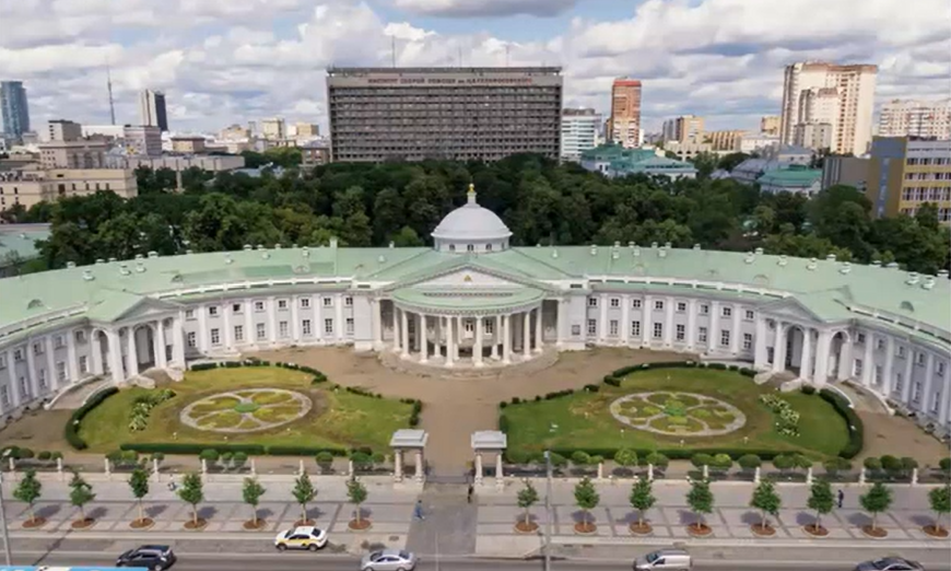 Photo of large building with large pillars and a large lawn