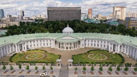 Photo of large building with large pillars and a large lawn