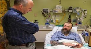 Dr. Ojemann standing by Gary Williams bedside